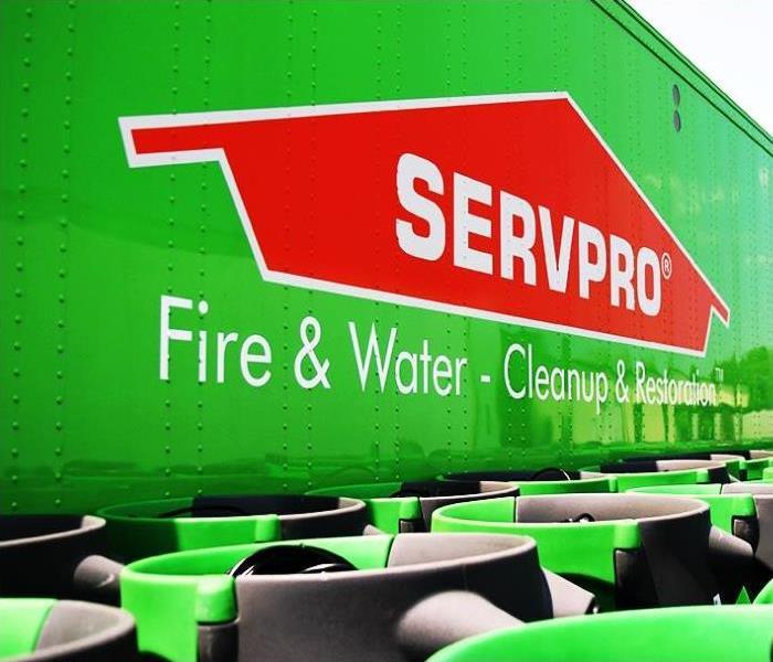 Green warehouse with SERVPRO orange roof and equipment