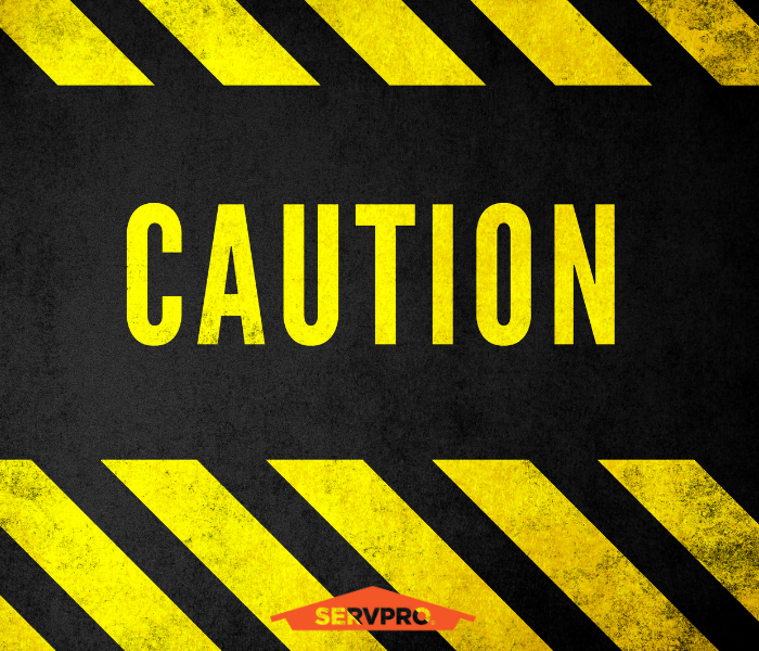 Caution Tape background with SERVPRO roof logo